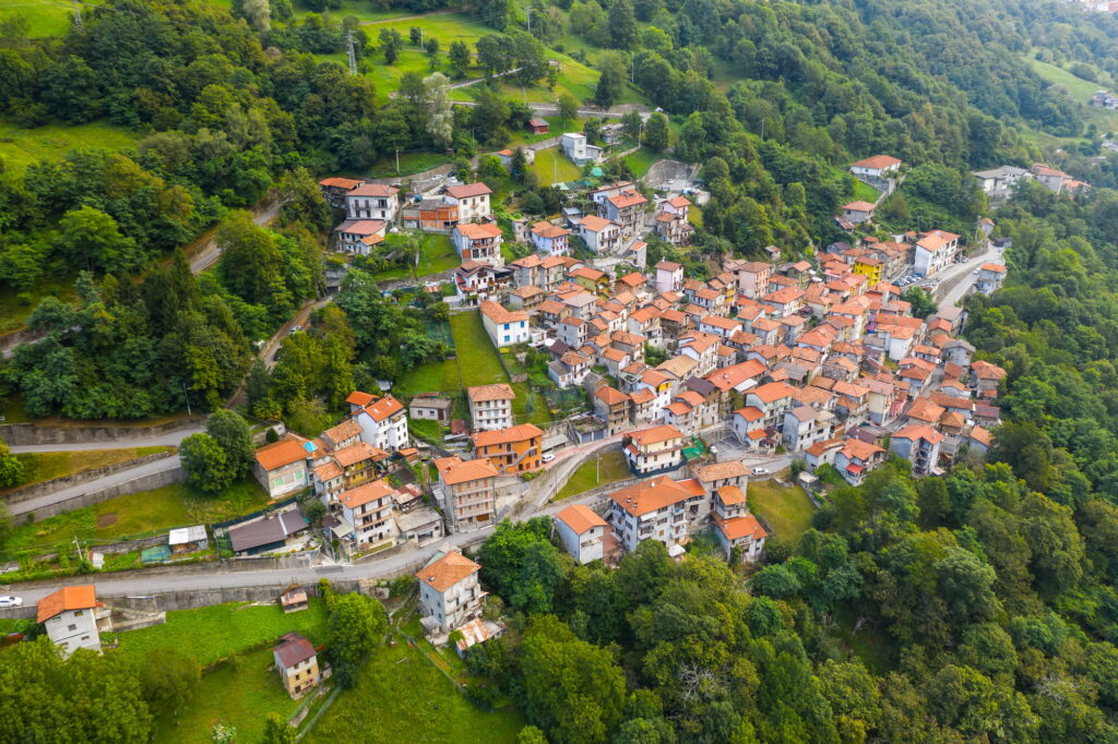 Arial view on mountain Italian village, Garzeno. High angle view of houses with red roofs amoung